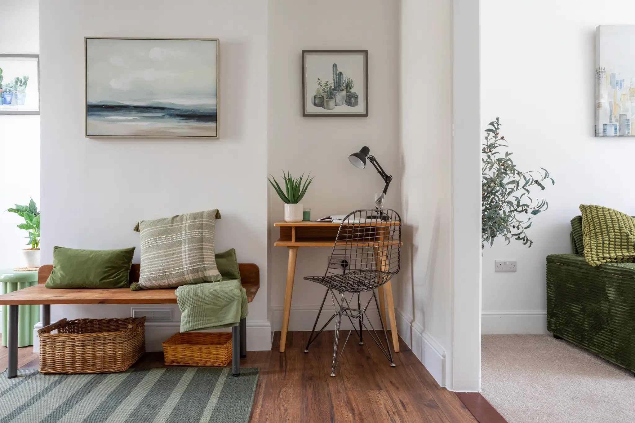 Hallway wider view with bench seating, wicker storage baskets, desk nook with anglepoise lamp, framed landscape and cactus prints, Bristol renovation interior photography