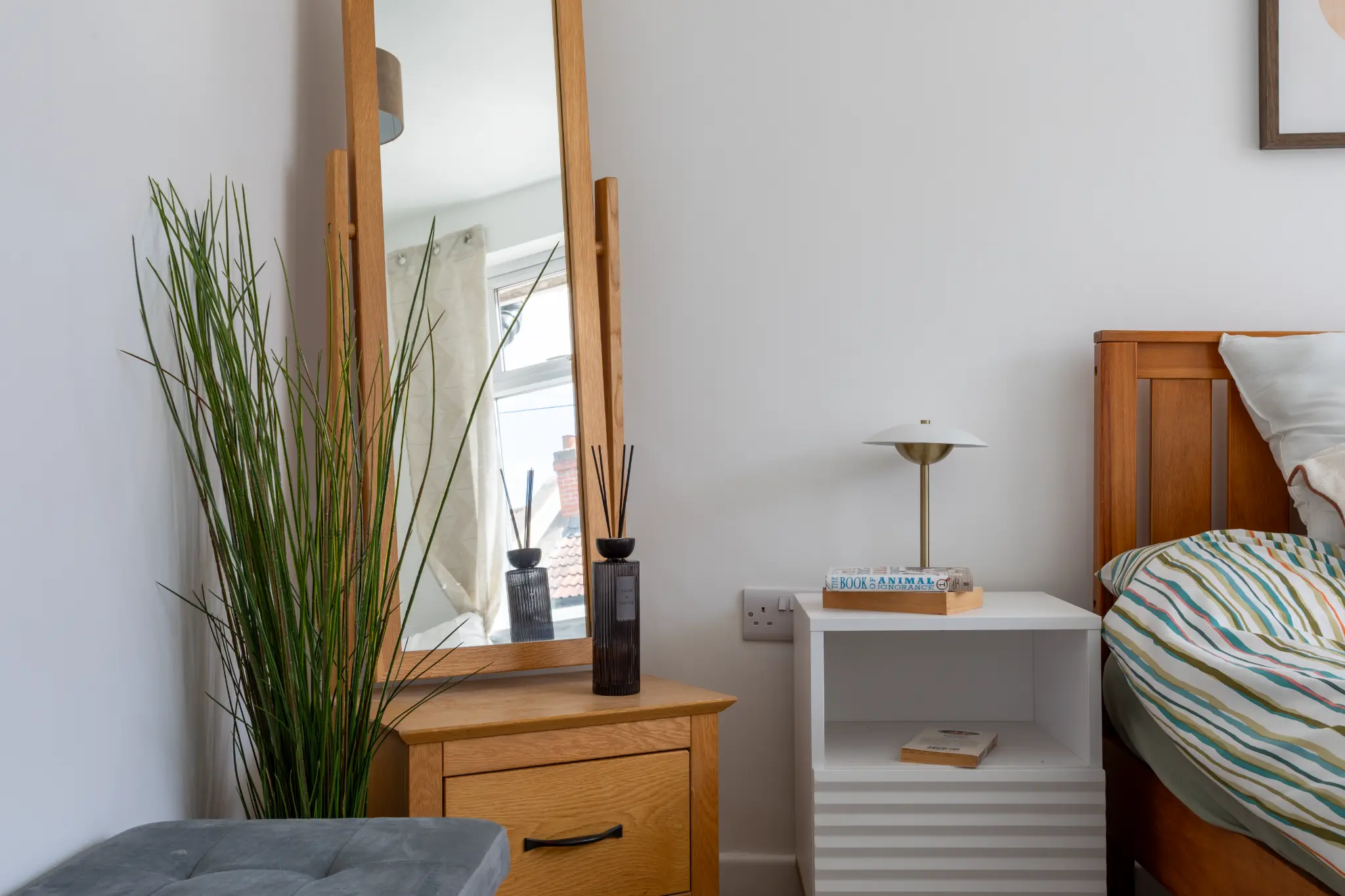 Bedroom detail showing nightstand styling and window light