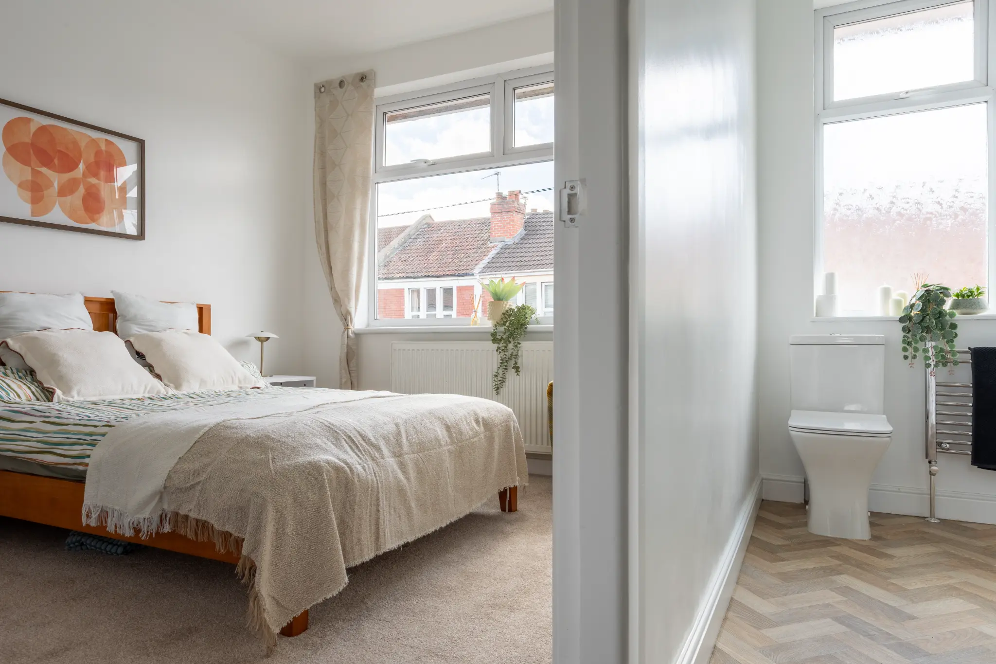 Master bedroom and en-suite bathroom with herringbone floor and chrome towel rail