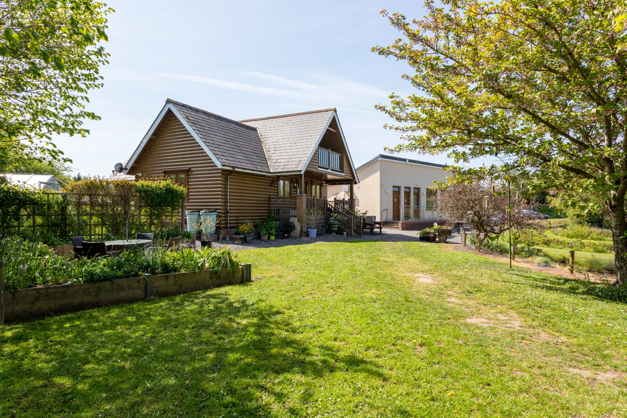 The lodge front garden with raised beds and mature trees