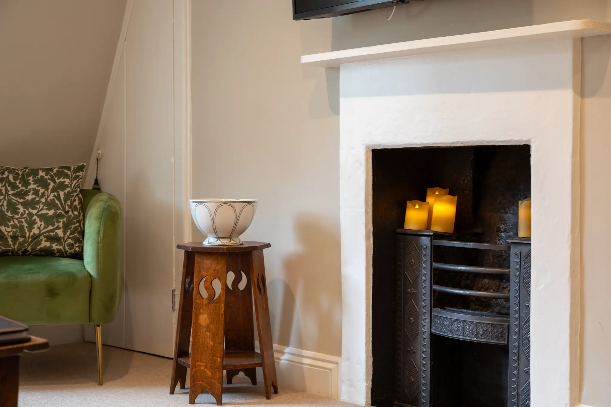 Period Victorian fireplace with candles and green armchair at Milsom Apartments