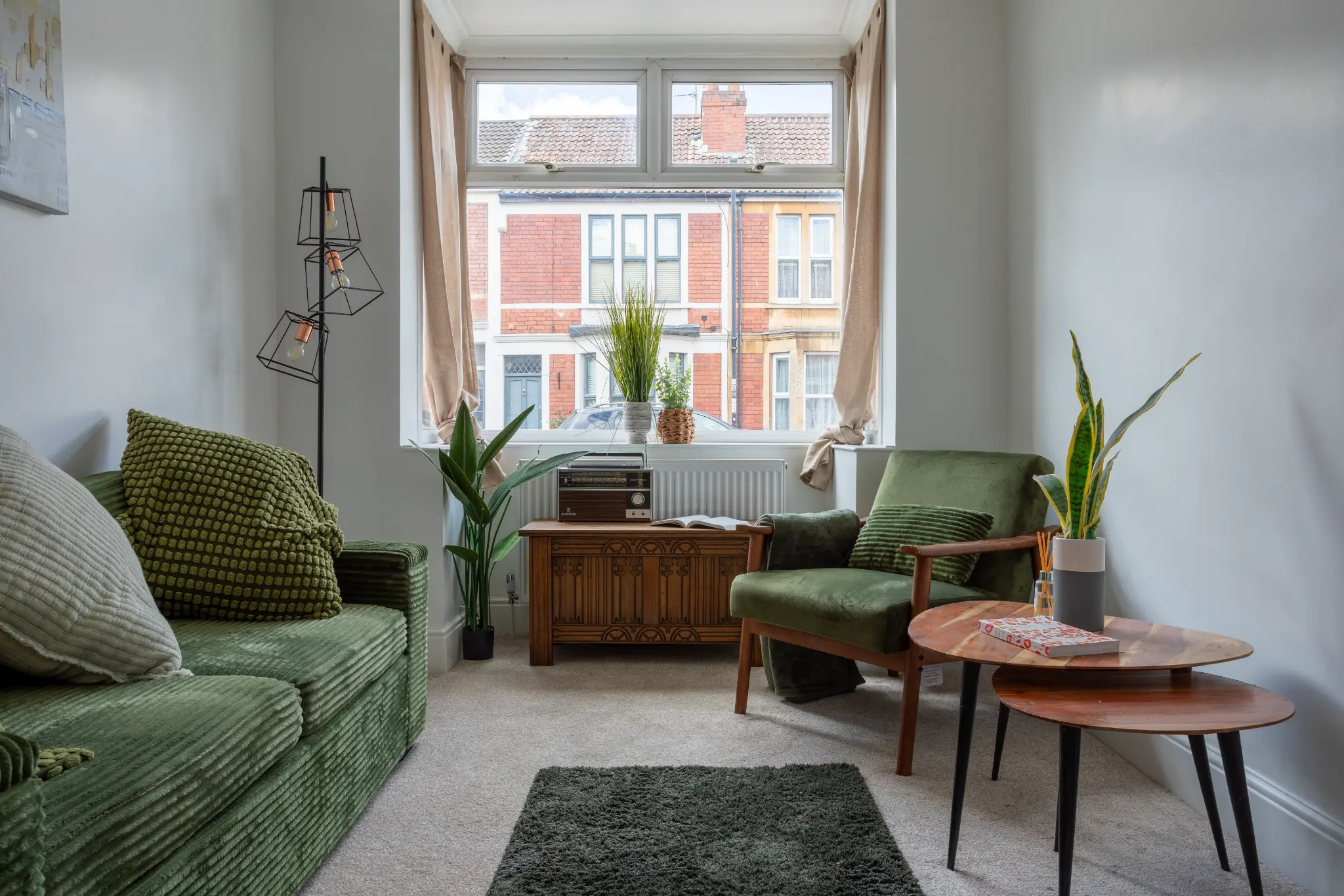 Bristol renovation living room with green corduroy sofa, mid-century armchair and bay window