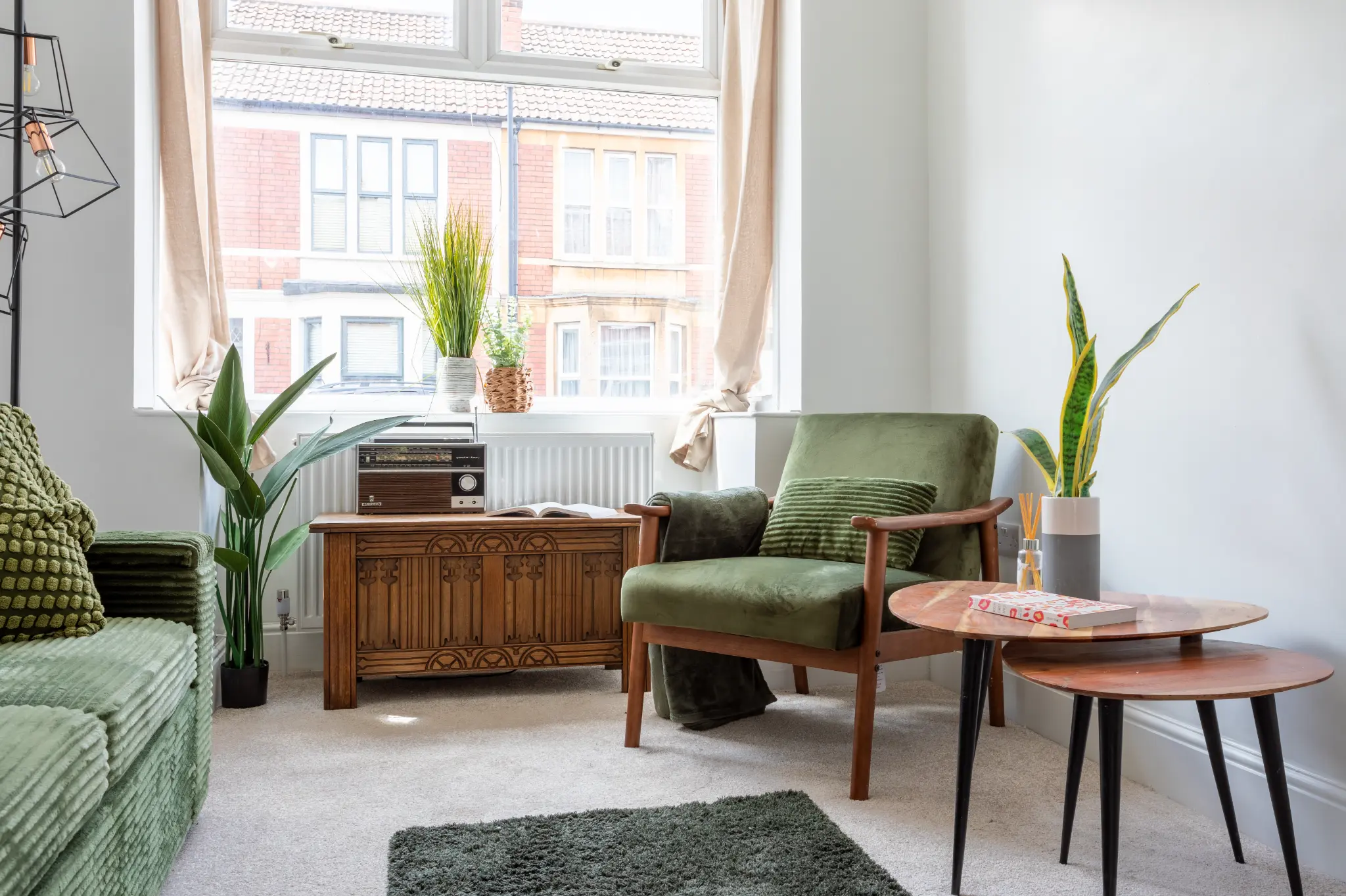 Compact living room in a one bedroom let, styled with a green sofa