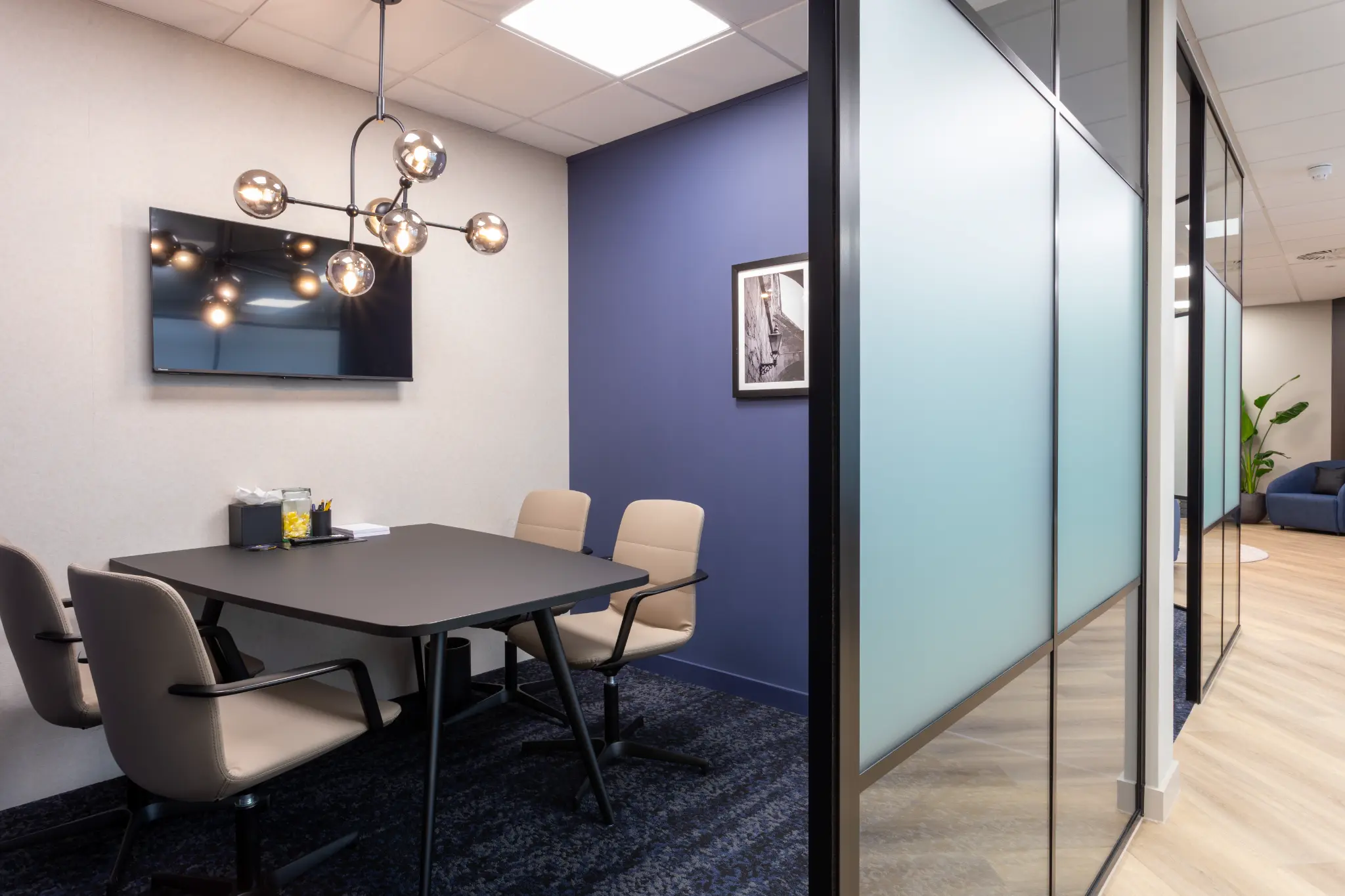 Meeting room with sputnik chandelier and purple accent wall