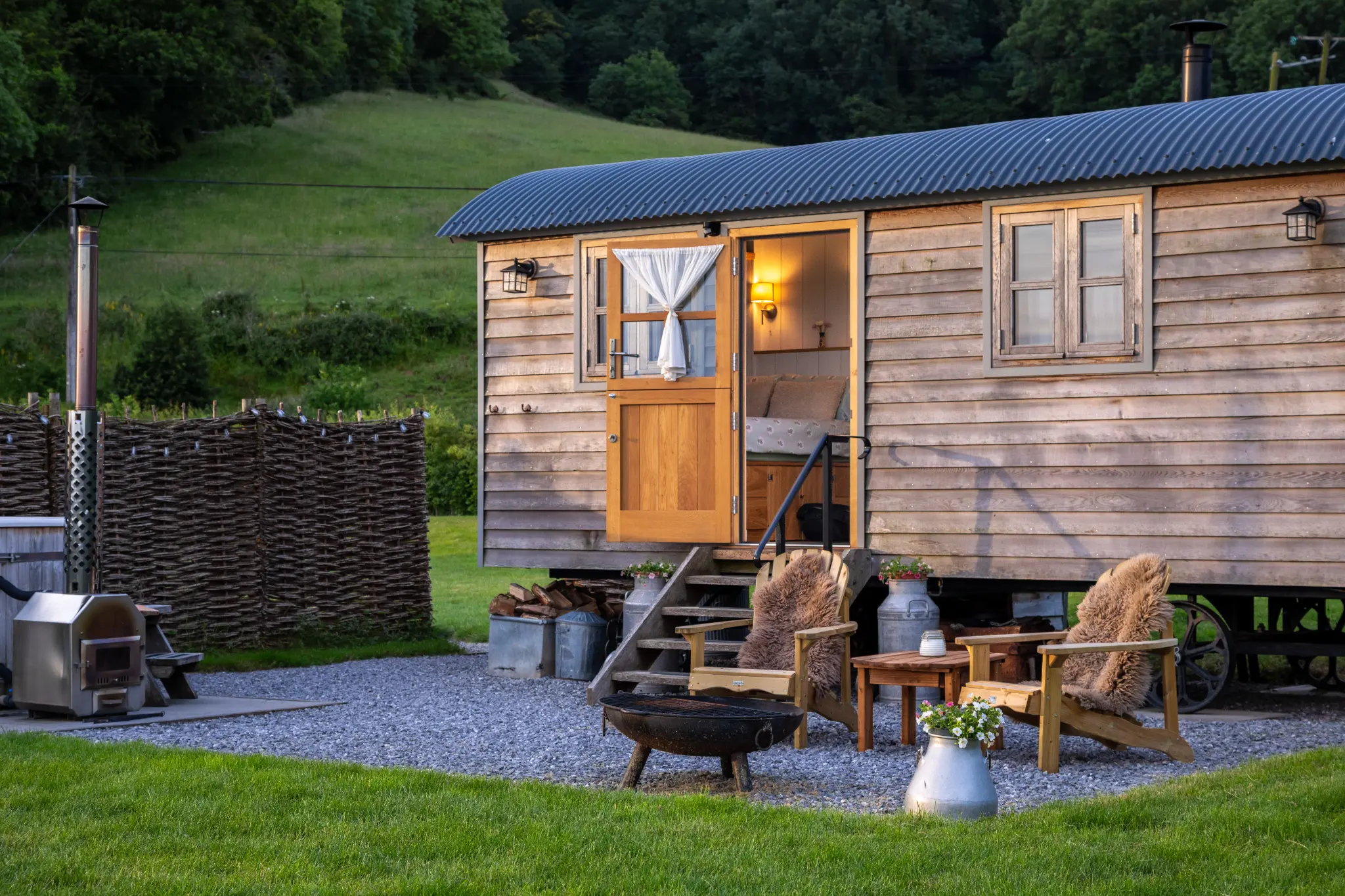 Shepherd's hut at golden hour with a lit fire pit