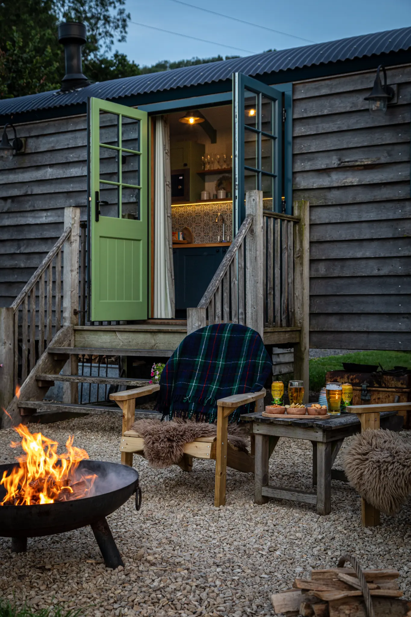 Shepherd's hut at dusk with the fire pit alight