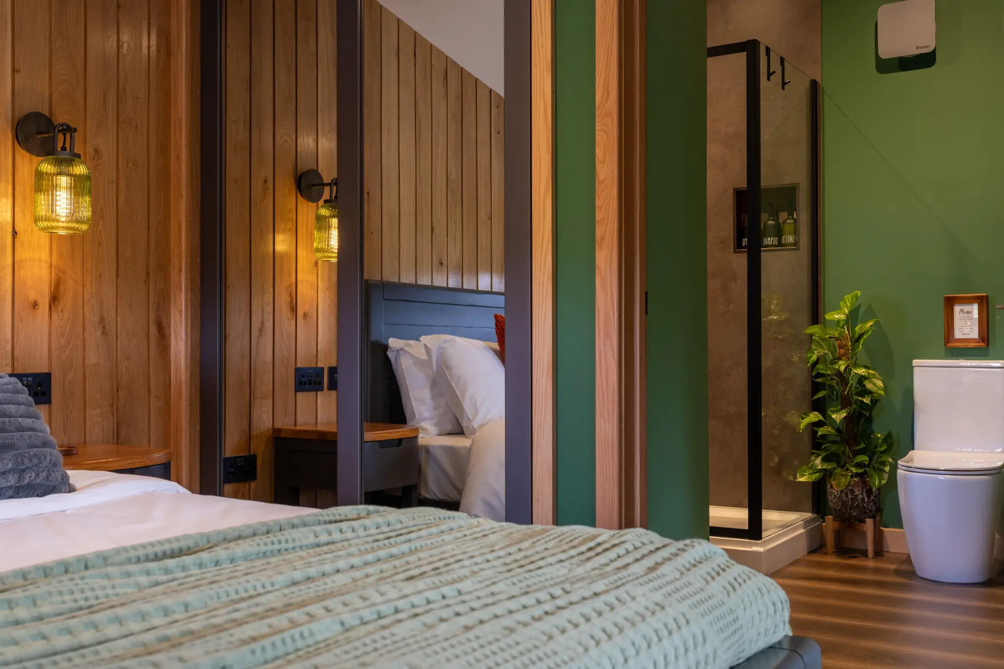 Bedroom foreground with a view through to the green en-suite shower room