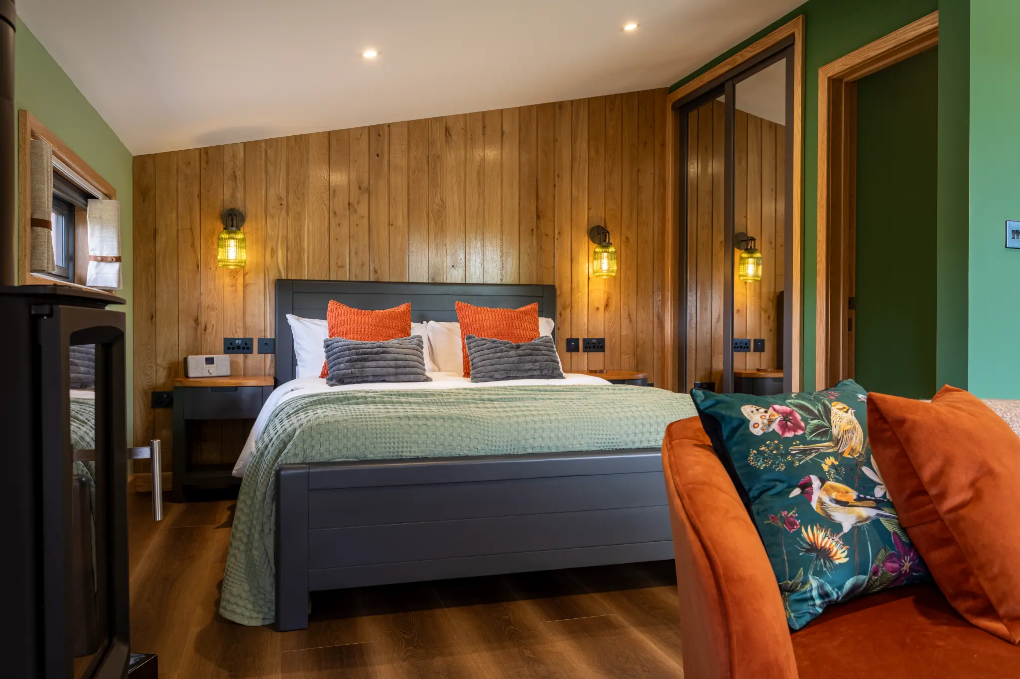 Bed with rust cushions and the en-suite door open beyond at Ochre Hill