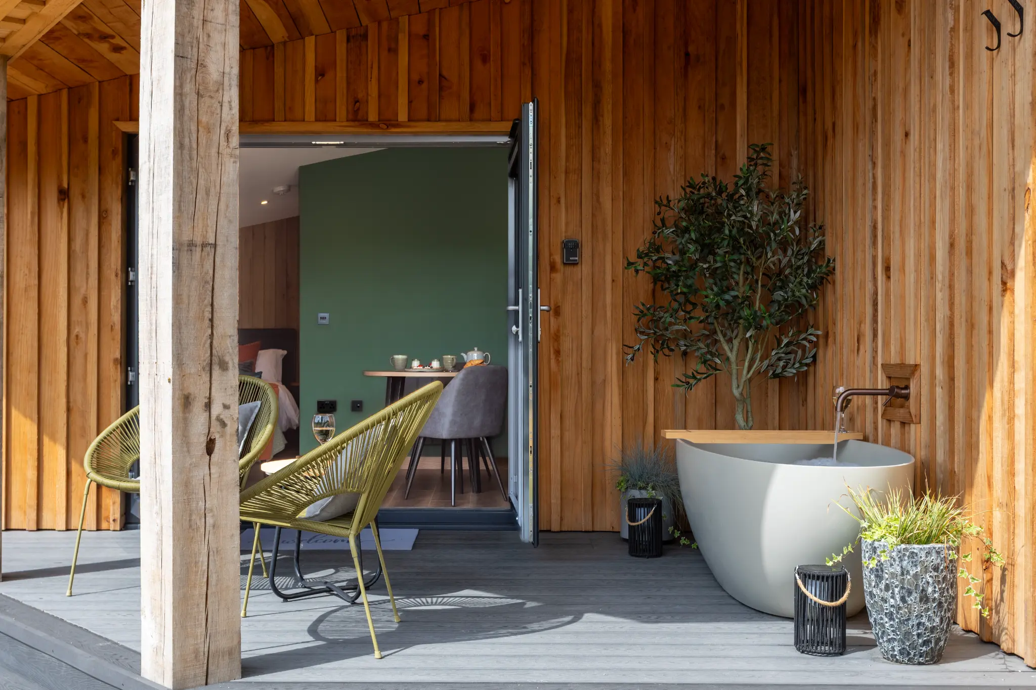 Deck seating with the cabin door open to the interior and the stone bath alongside