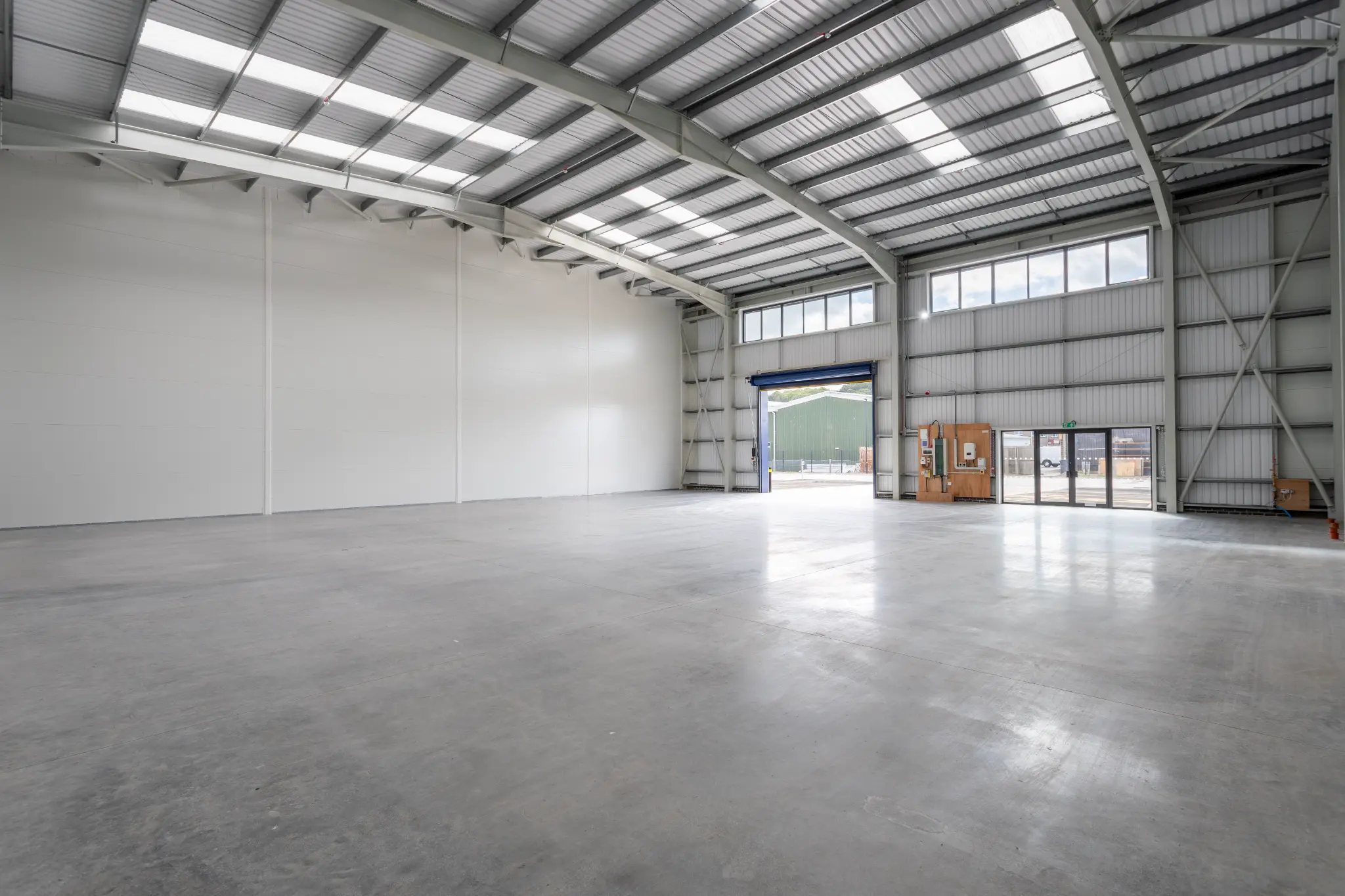 Empty warehouse interior with concrete floor and exposed steel portal frame